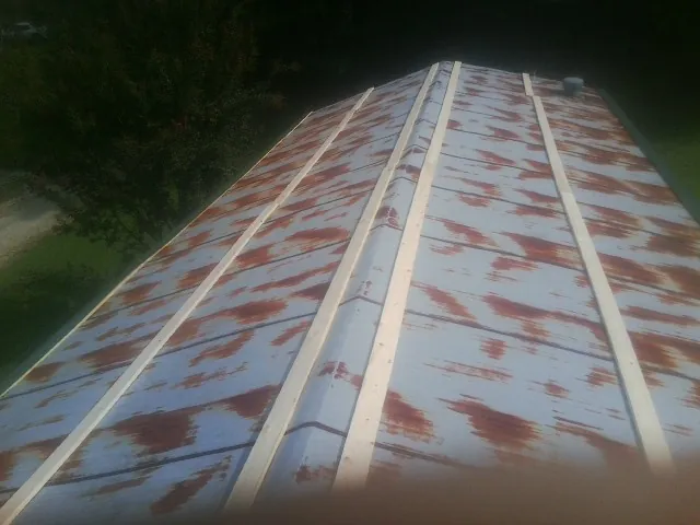 Rusted metal roof panels with new wood purlins before replacement — Storm Damage Roof Repair in Pickrell by Roofing Brothers