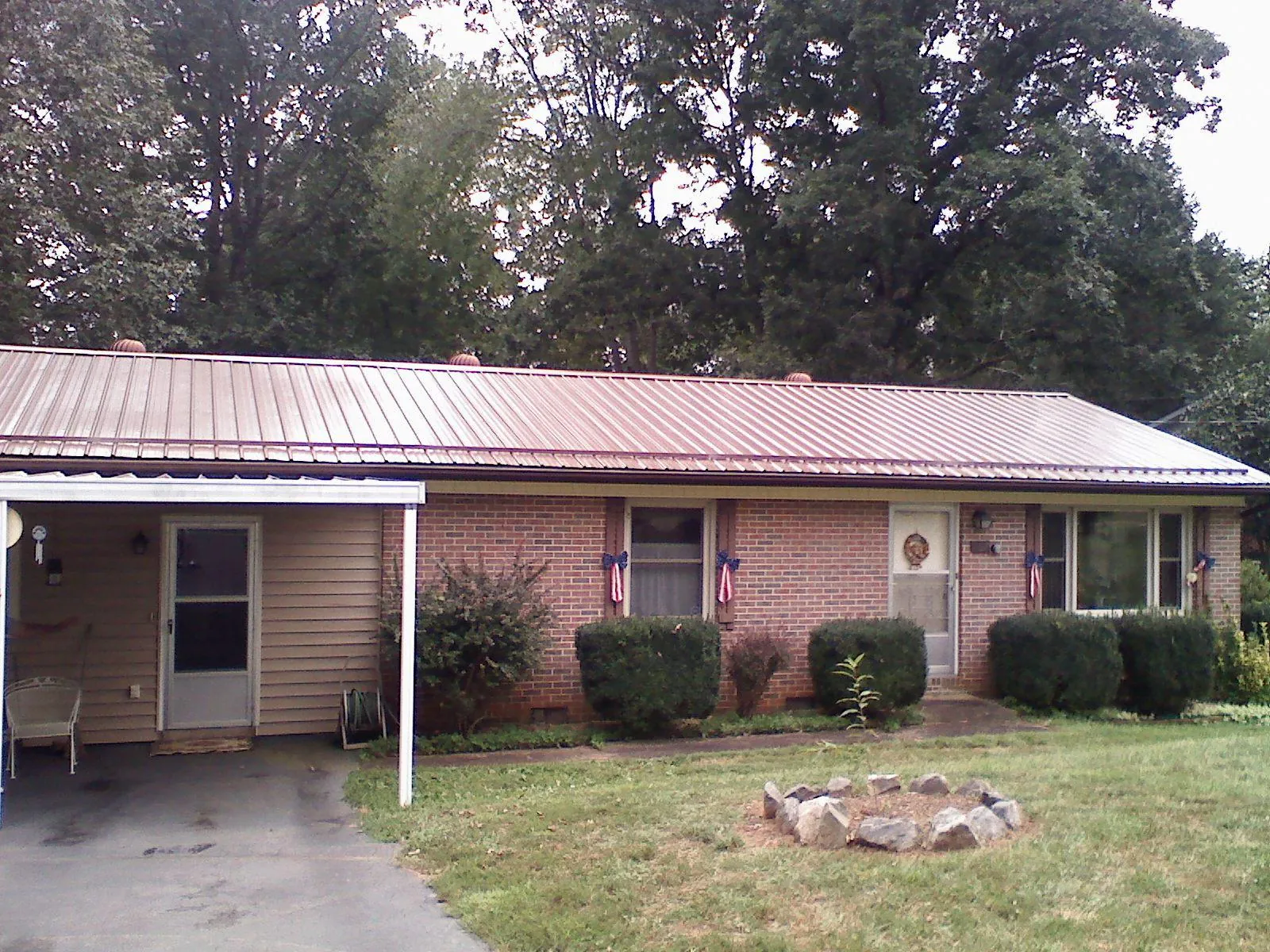 Bronze metal roof and carport on a brick ranch home — Roof Repair work by our crew in Pickrell
